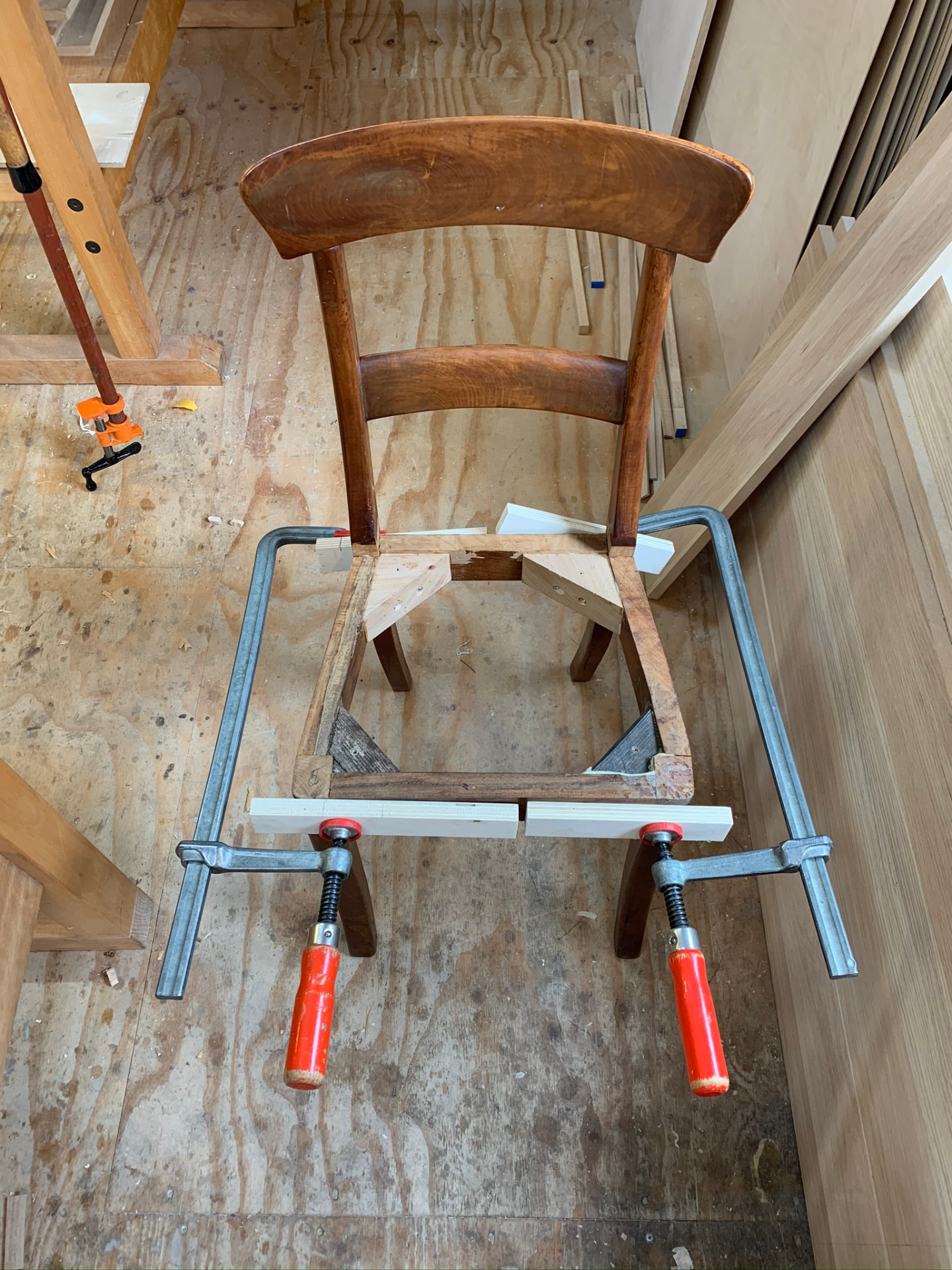 Het frame onder klemspanning, met twee nieuwe hoekklossen die de hoeken van het zitvlak versterken