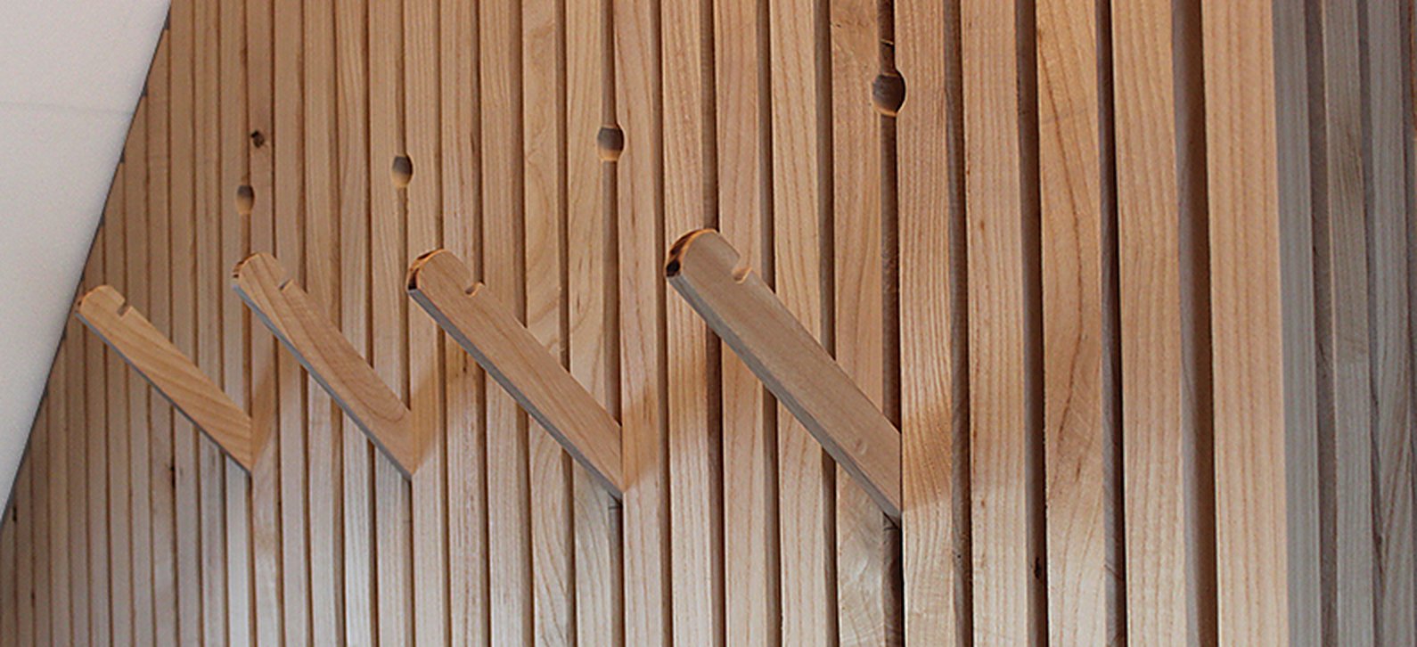 Uitschuifbare houten kledinghaken in de lattenwand
