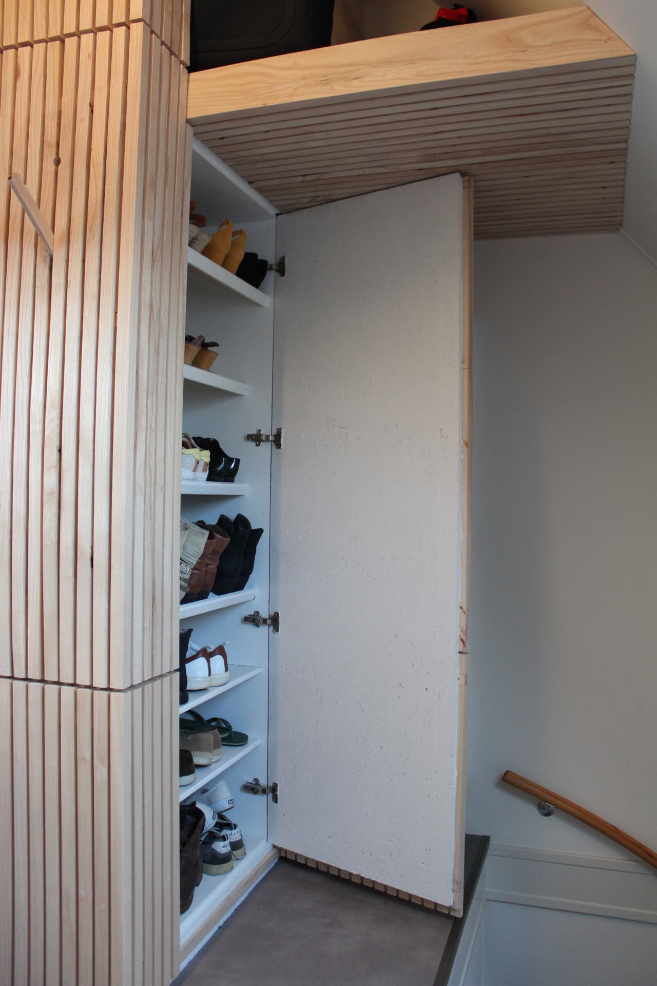 De verborgen schoenenkast met open deur en legplanken
